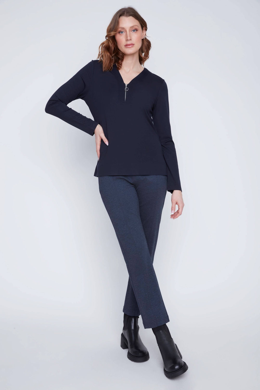 Chandail encolure en V zippée porté par modèle, design minimaliste et moderne avec manches longues, coupe droite, pour un look polyvalent.