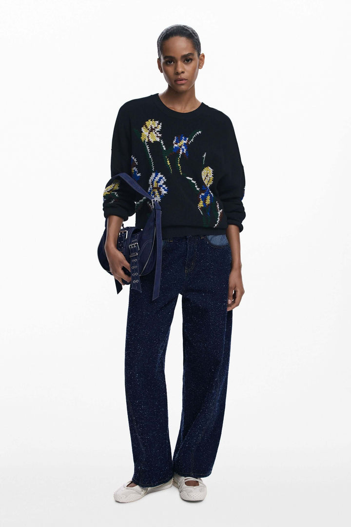 Modèle portant un Chandail à fleurs brodées avec motifs floraux colorés, combinant confort et style décontracté et élégant.