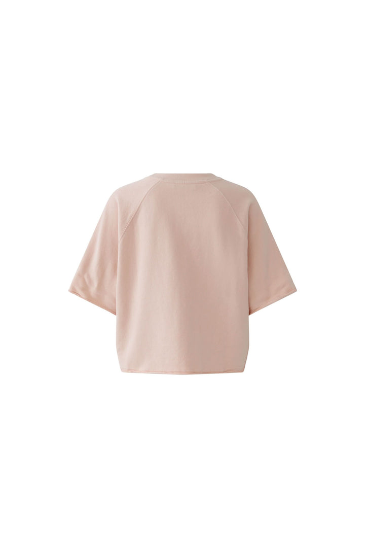 Chandail imprimé graphique à manches courtes de couleur beige, coupe ample et raccourcie, idéal pour un look décontracté et moderne.