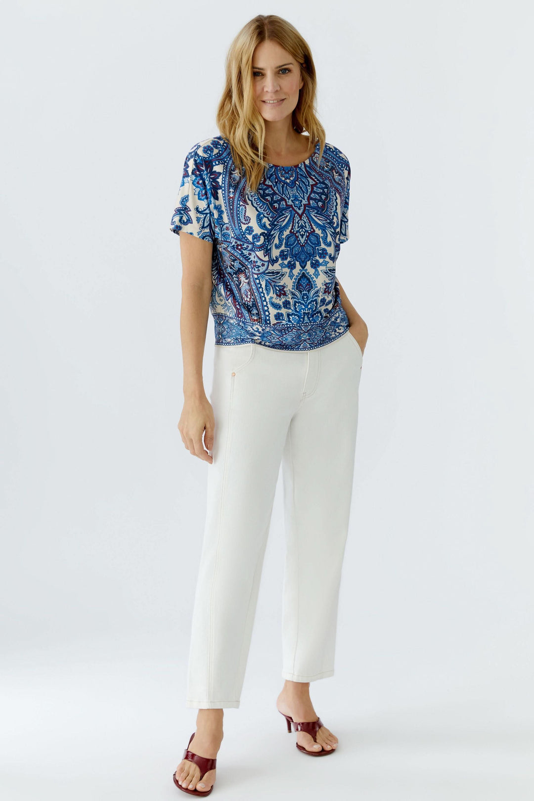 Femme portant un chandail imprimé à manches courtes avec motif cachemire expressif, confortable et polyvalent pour un style décontracté.