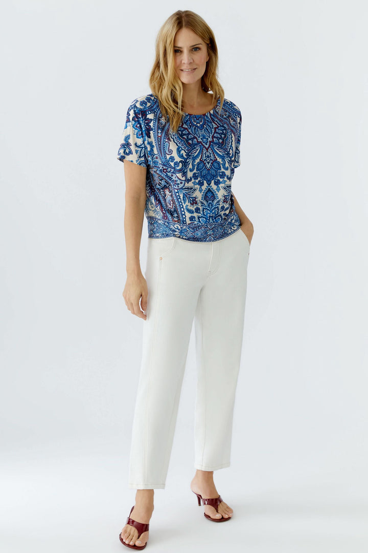 Femme portant un chandail imprimé à manches courtes avec motif cachemire expressif, confortable et polyvalent pour un style décontracté.