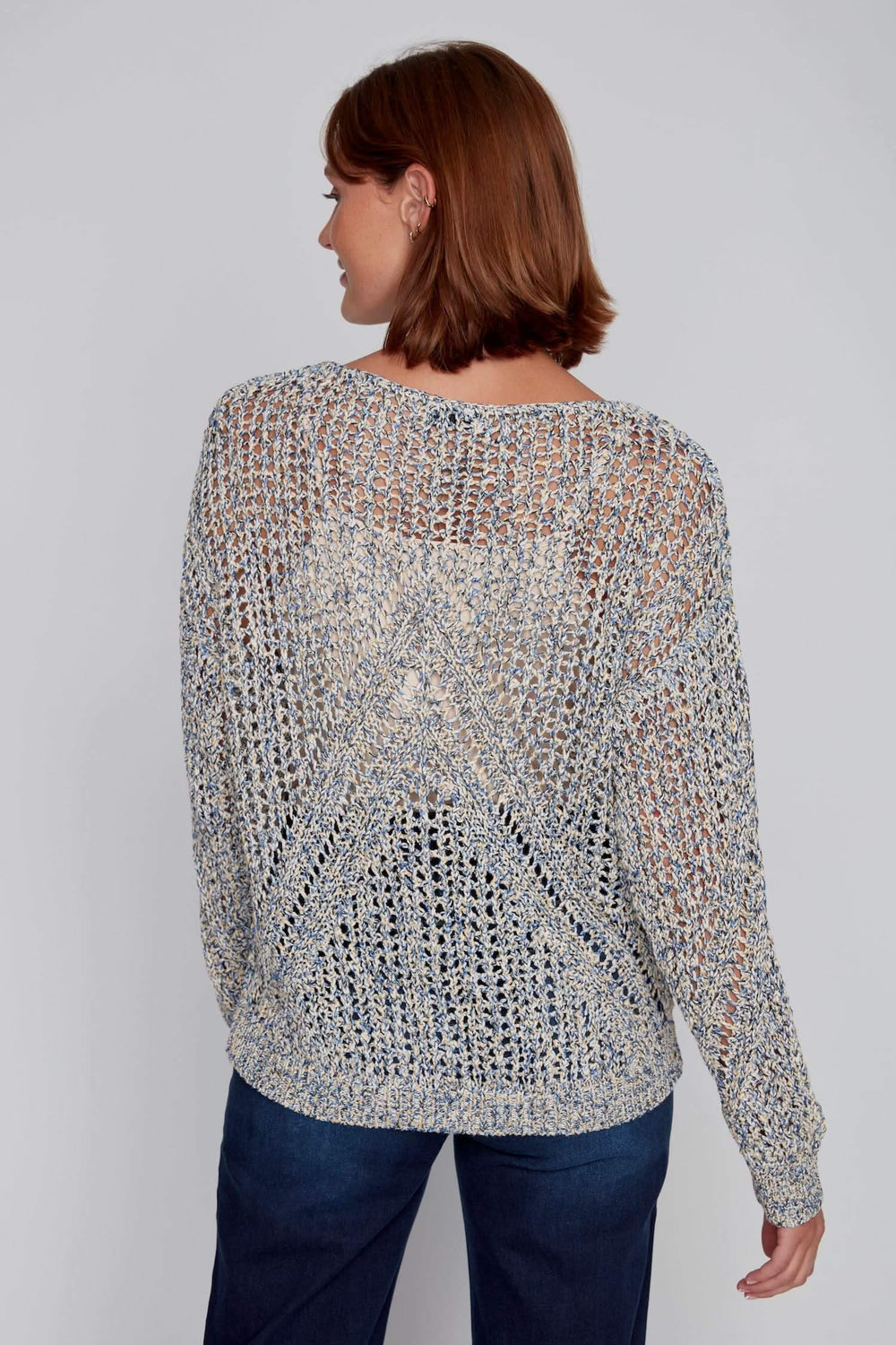 Chandail à maille ajourée multicolore avec motif en V, encolure dégagée, porté par une femme.