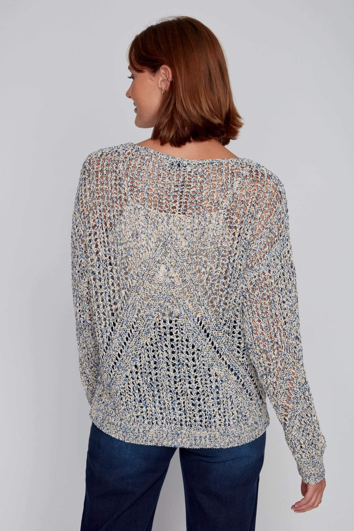 Chandail à maille ajourée multicolore avec motif en V, encolure dégagée, porté par une femme.
