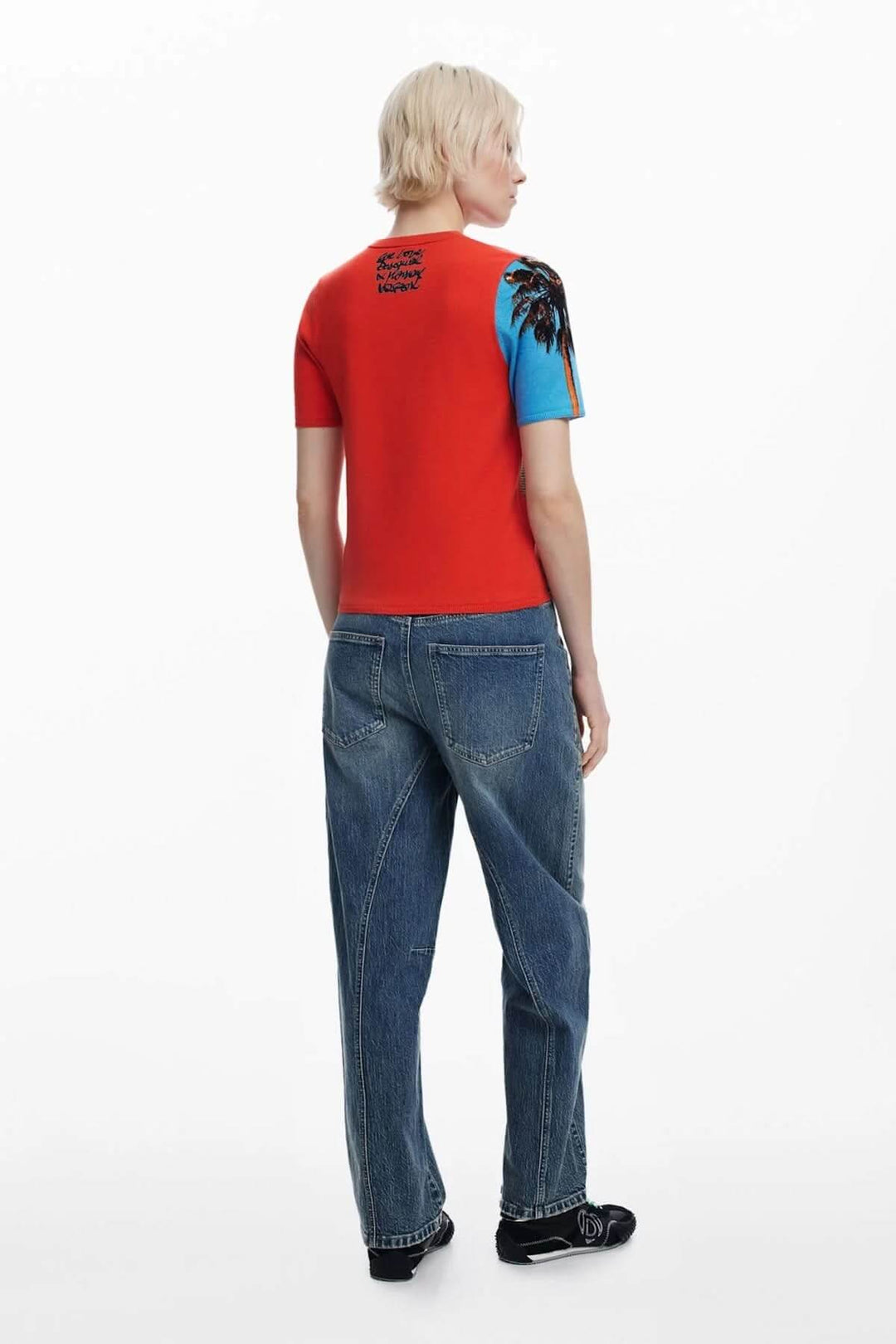 Chandail à manches courtes rouge et bleu avec design graphique et coupe ajustée, porté avec un jean.