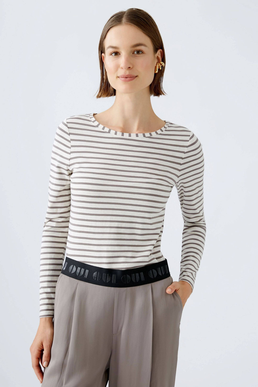 Femme portant un Chandail à manches longues Sumiko avec rayures horizontales, coupe ajustée et encolure ronde, look épuré et confortable.