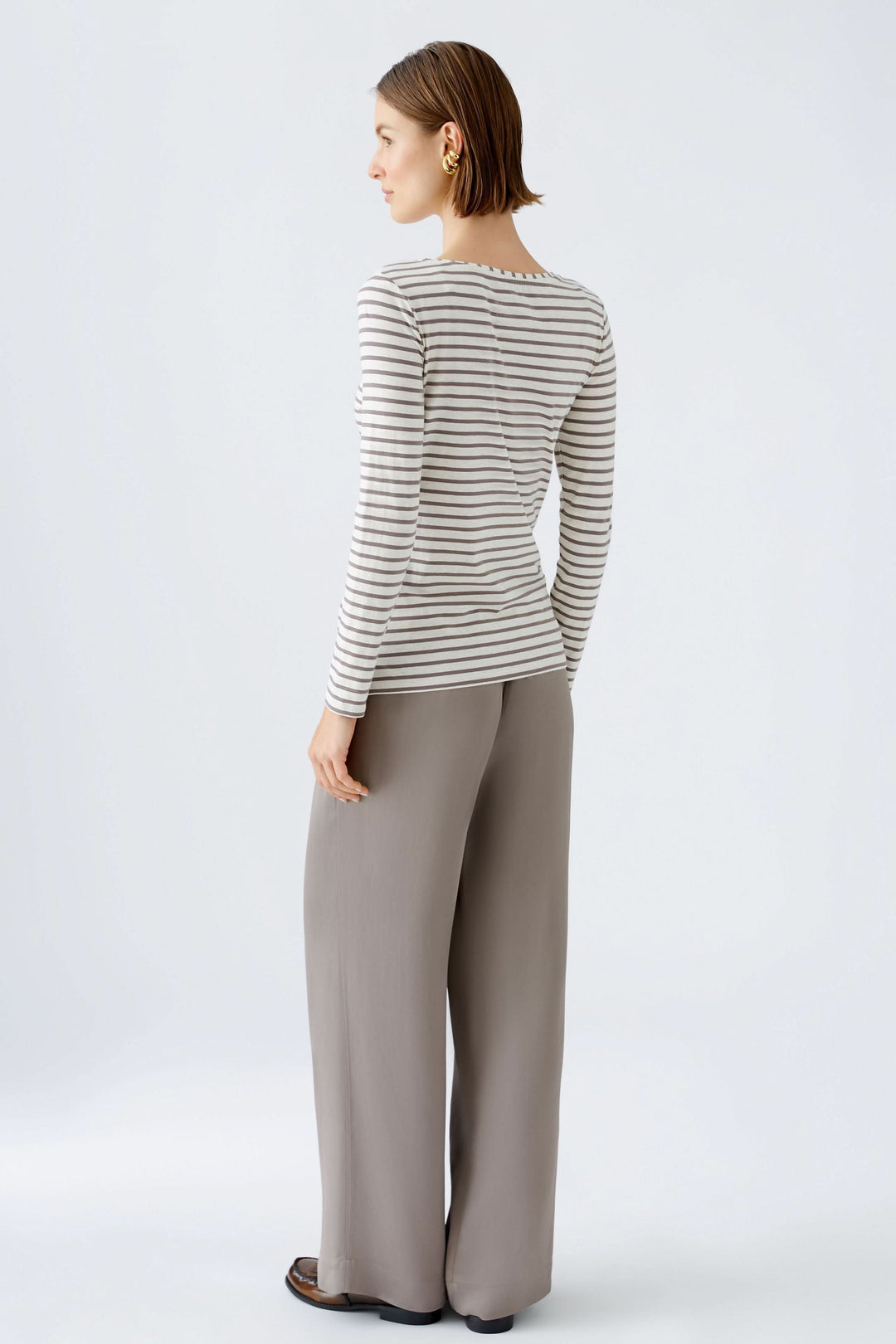 Femme portant Chandail à manches longues Sumiko à rayures, coupe ajustée, encolure ronde, style épuré et intemporel.