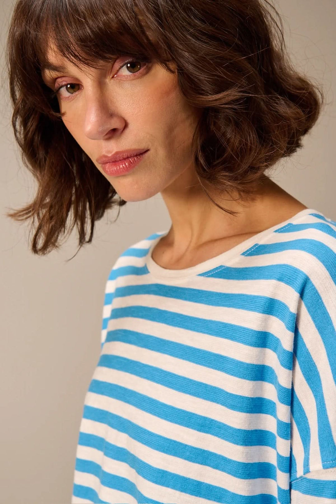 Chandail à manches longues rayé coupe décontractée en tissu doux avec encolure ronde, porté par une femme, fond neutre.