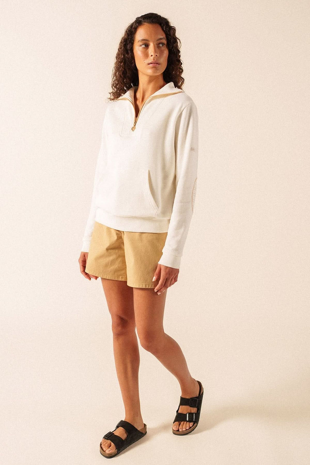 Modèle portant le chandail molletonné LOU avec demi-glissière et coudières, style sport-chic et coupe confortable.