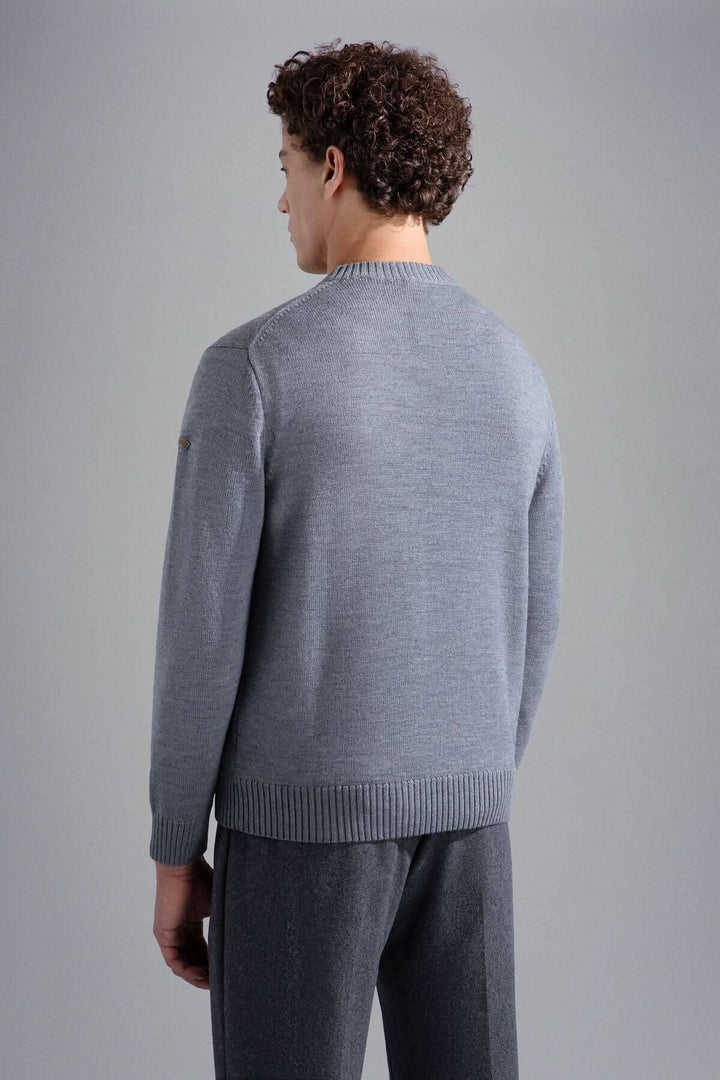 Homme de dos portant un pull gris clair avec des bords-côtes, style décontracté chic.