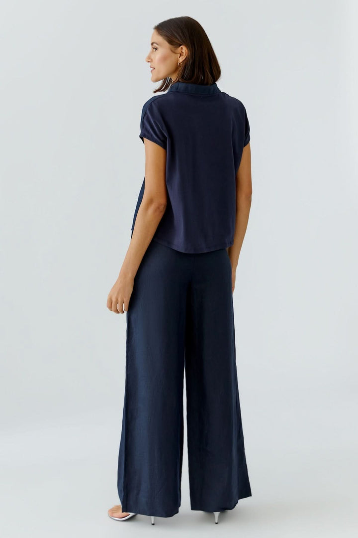 Chandail polo fluide à manches courtes vue arrière avec coupe moderne et épurée, idéal pour un style minimaliste et confortable.