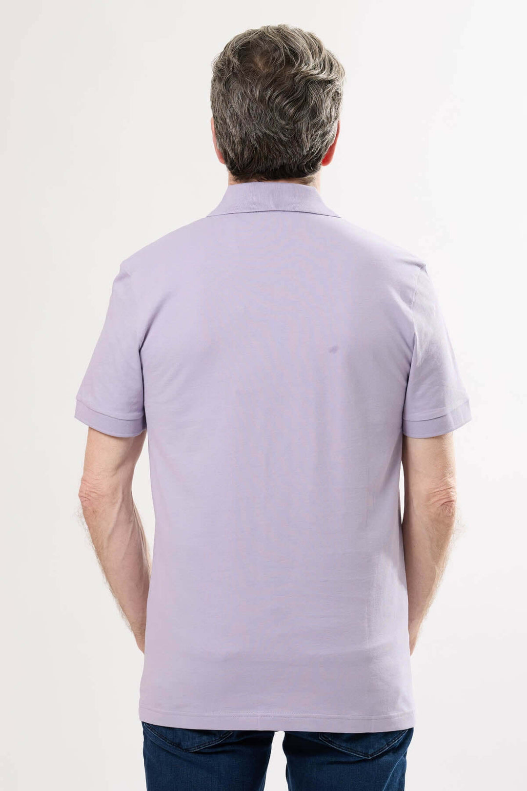 Homme vue de dos portant un polo à logo BOSS de couleur lilas, style classique et décontracté.
