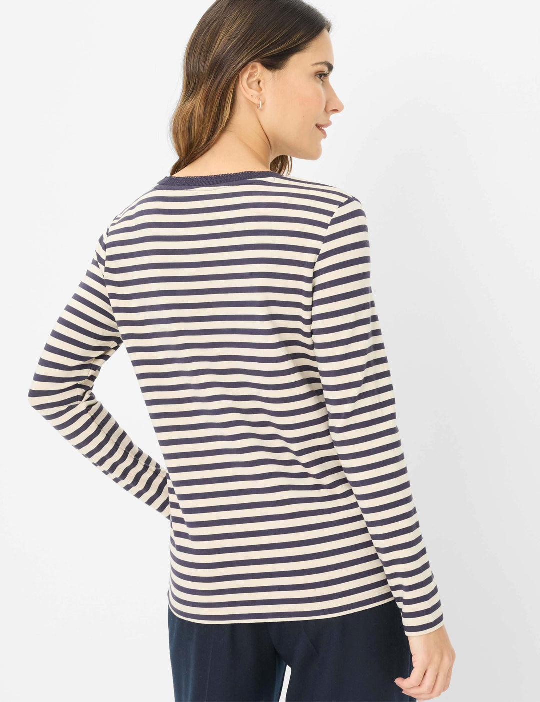 Femme portant un chandail rayé CARINA L à manches longues et coupe confortable, vu de dos, montrant les rayures classiques.