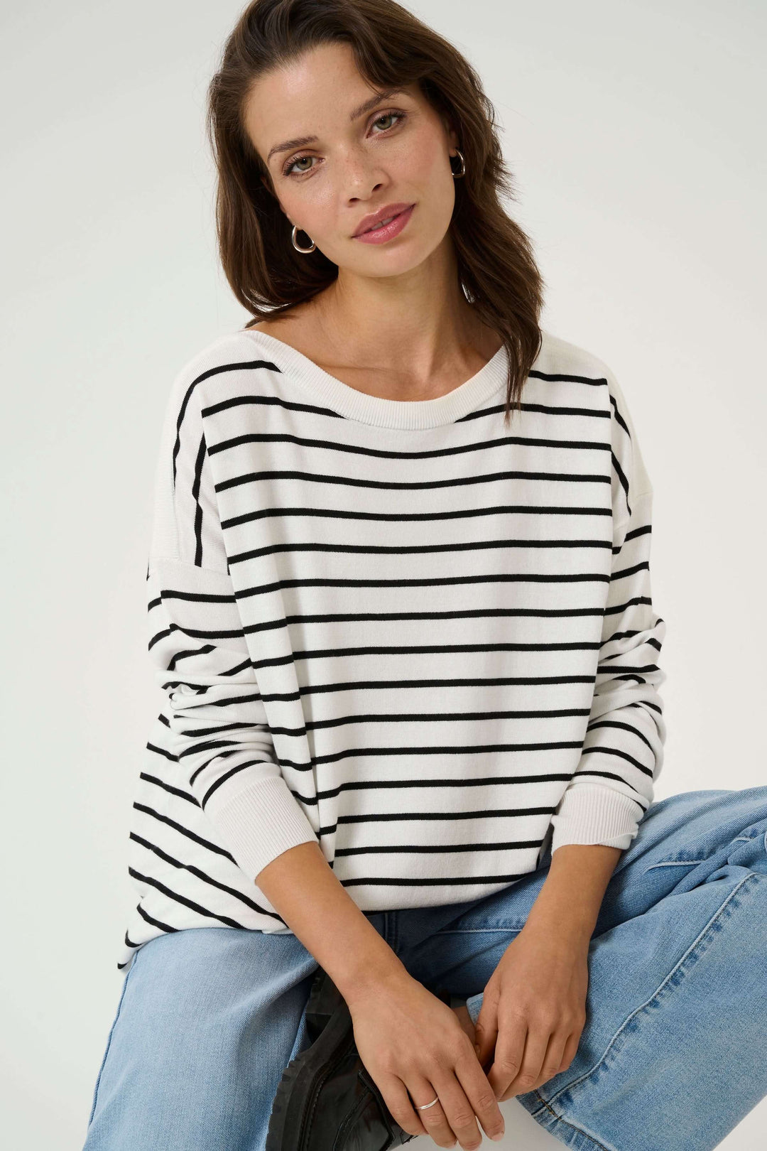 Chandail rayé au style marin avec coupe ample, encolure dégagée et manches longues, parfait pour un look casual-chic.