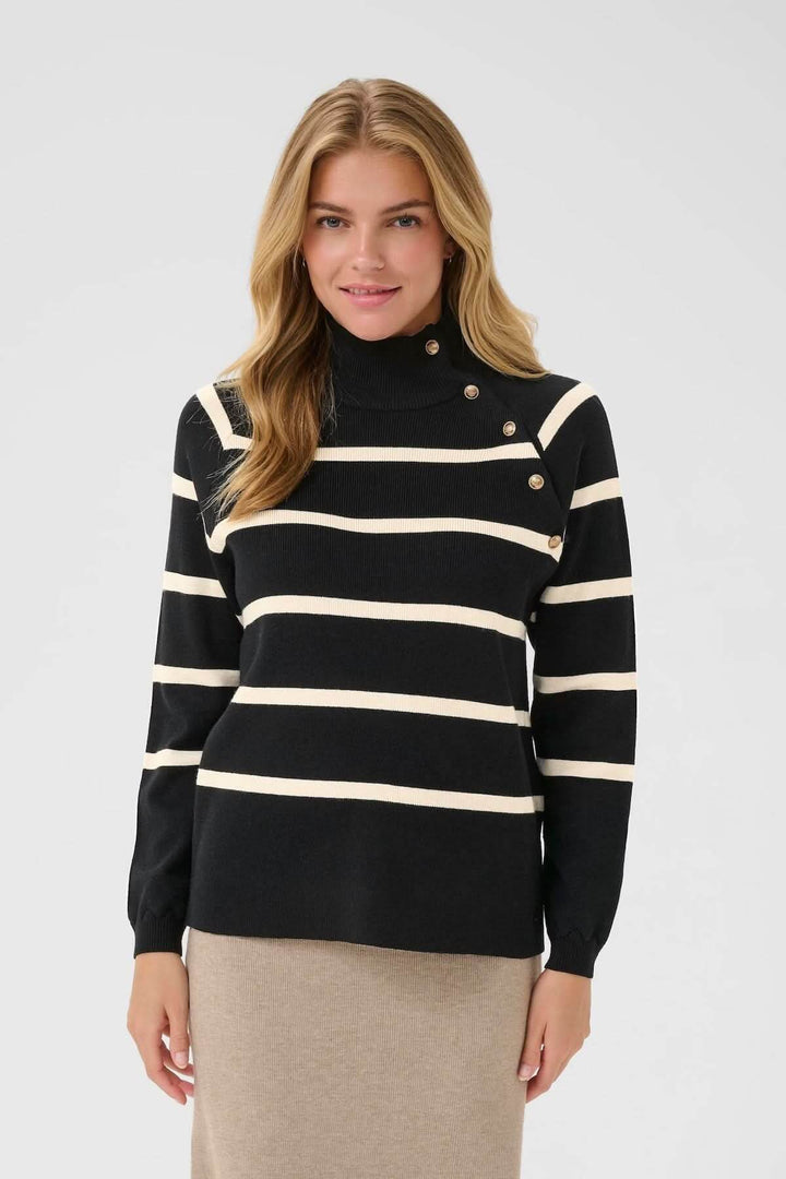 Chandail rayé à col montant avec boutons décoratifs, style marin chic, porté avec jupe.