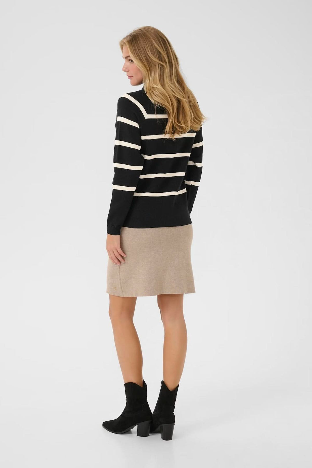 Chandail rayé à col montant noir et crème, porté avec une jupe beige et des bottines noires, vue arrière.