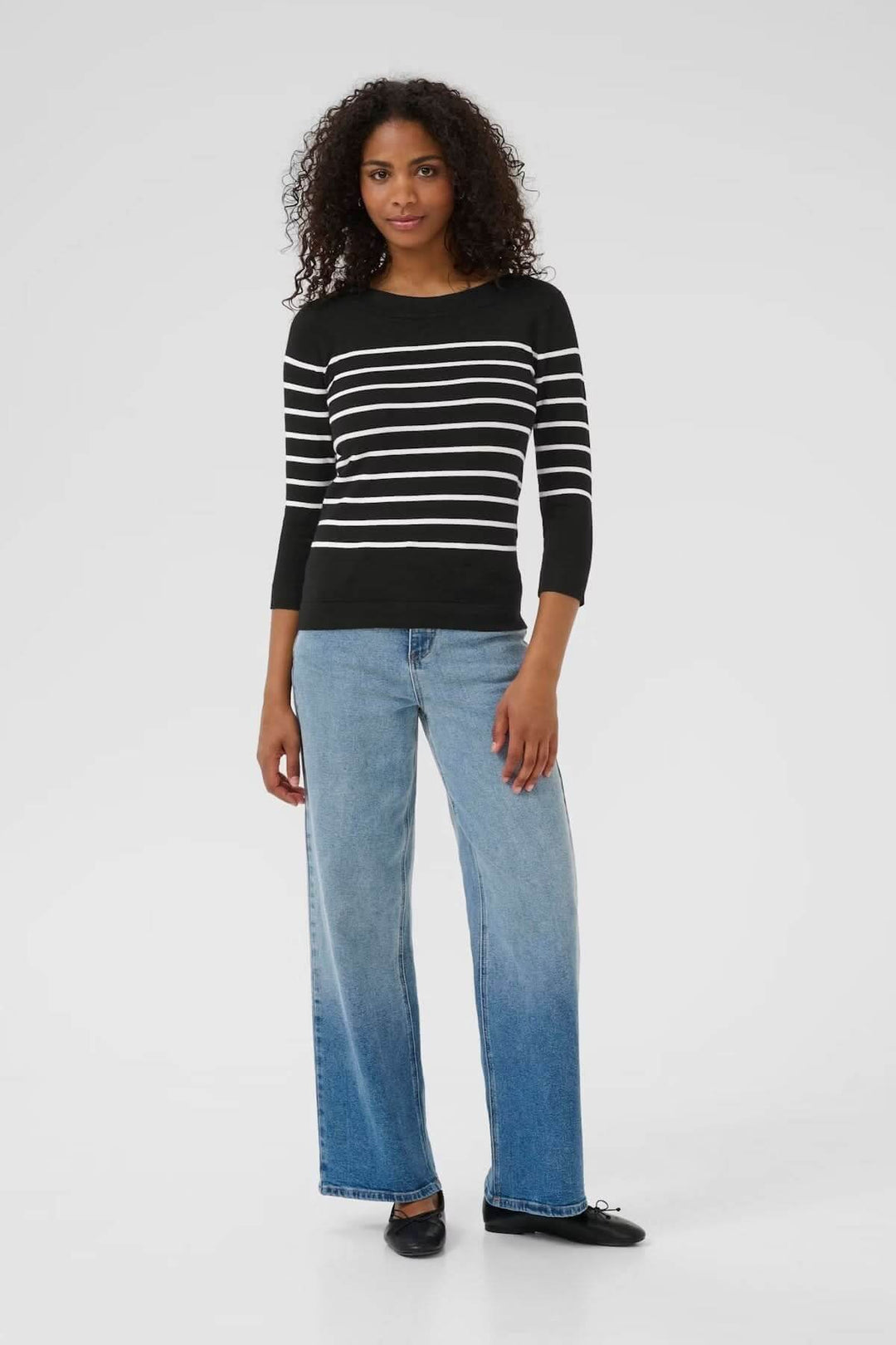 Chandail rayé en maille souple avec encolure bateau et manches trois-quarts, porté avec un jean décontracté.