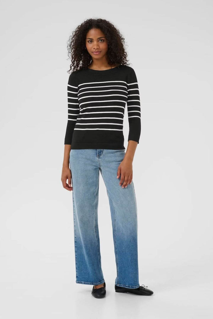 Chandail rayé en maille souple avec encolure bateau et manches trois-quarts, porté avec un jean décontracté.