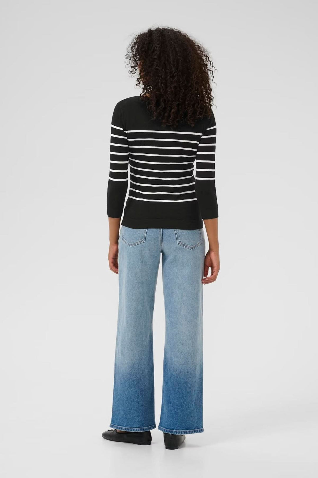 Chandail rayé en maille souple avec manches trois-quarts, porté avec un jean ample, vue arrière.