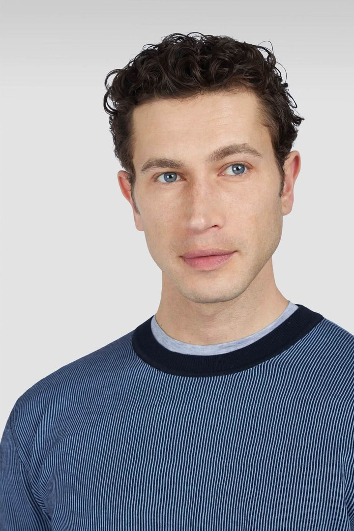 Homme portant un chandail bleu marine à rayures, avec encolure ronde et bordures contrastantes.