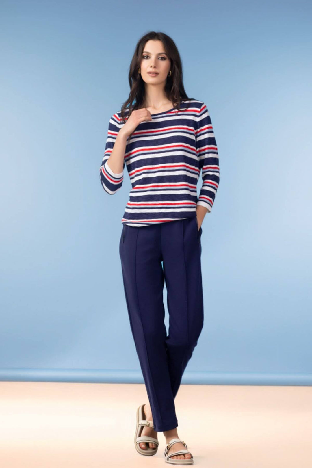 Femme portant un Chandail à rayures manches 3/4 avec encolure arrondie sur fond bleu.