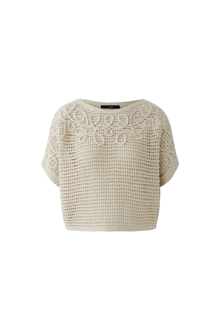 Chandail tricot ajouré texturé beige avec détails délicats et coupe fluide, idéal pour des superpositions élégantes.