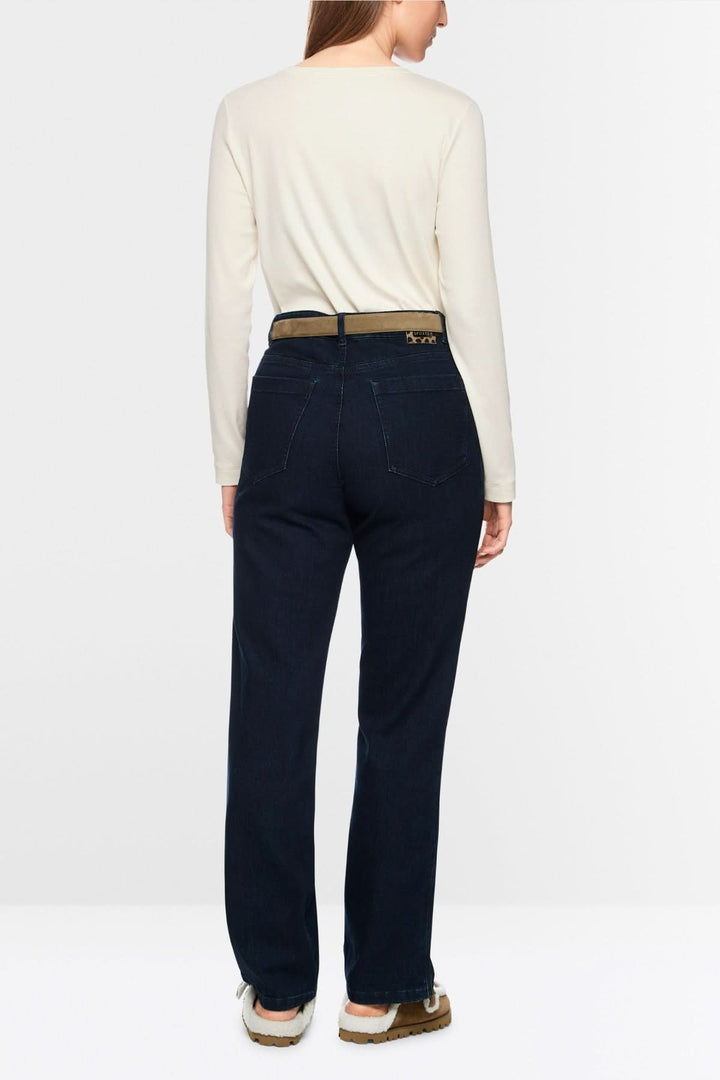 Femme portant un chandail unie à manches longues crème, assorti à un pantalon bleu foncé, vue arrière. Style minimaliste et chic.