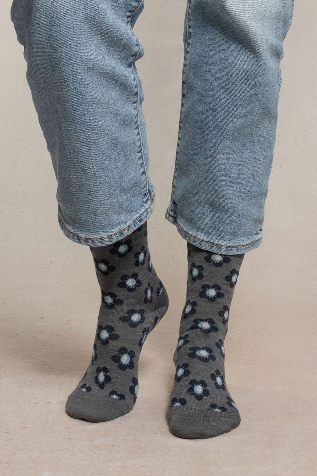 Chaussettes en maille à petit motif floral grises et bleues portées avec un jean, style casual et confortable.