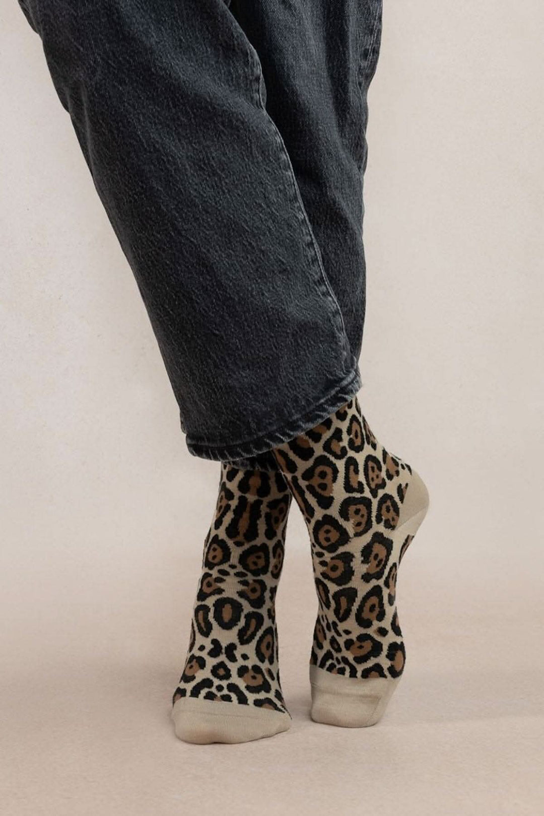Chaussettes léopard confortables avec motif intégral, portées avec un pantalon noir.