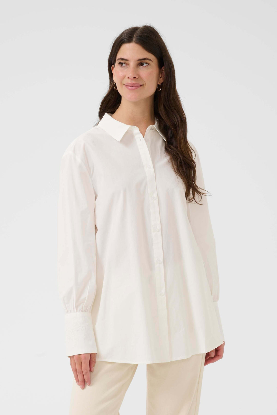 Femme portant la Chemise Alison blanche élégante au design épuré, idéale pour le bureau ou des looks décontractés.