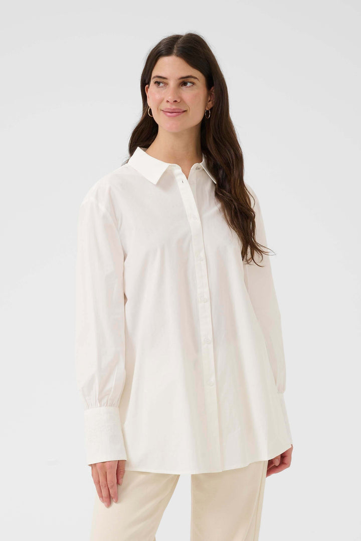Femme portant la Chemise Alison blanche élégante au design épuré, idéale pour le bureau ou des looks décontractés.