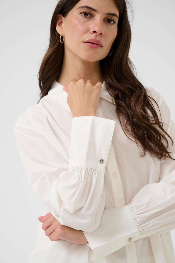 Femme portant la Chemise Alison blanche avec col classique et coupe fluide, idéale pour le bureau ou un look décontracté.