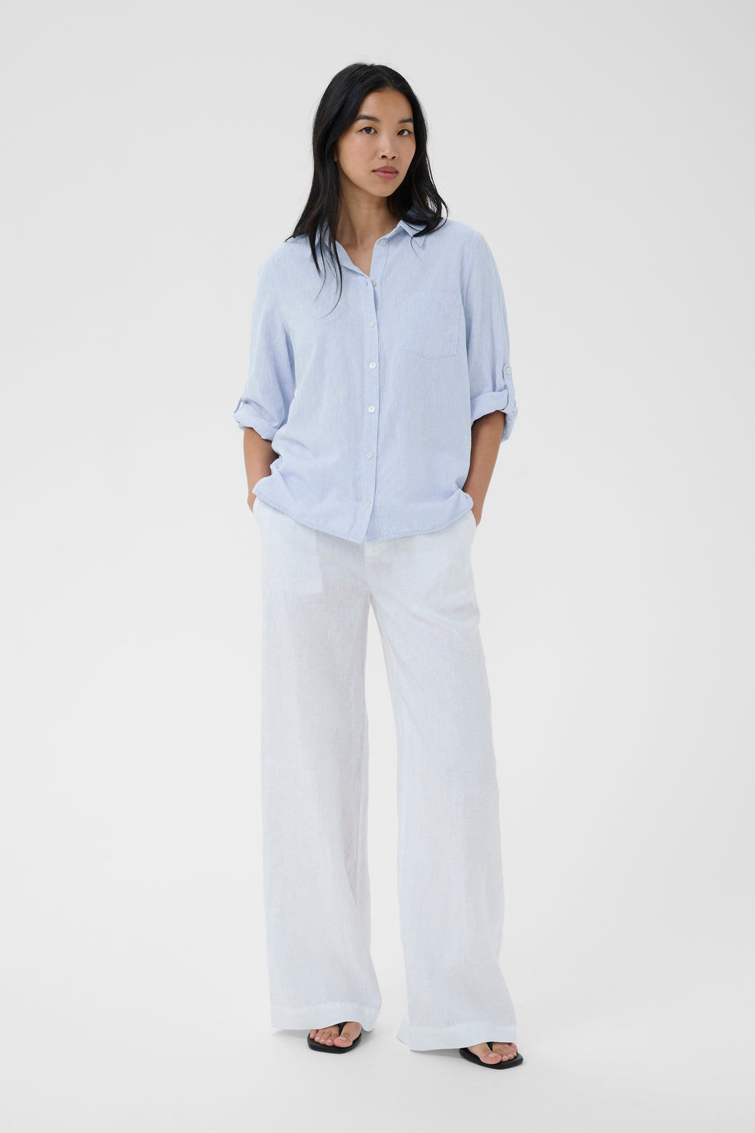 Femme portant la Chemise rayée Cindie avec manches 3/4, coupe fluide et col classique, idéale pour un look décontracté et structuré.