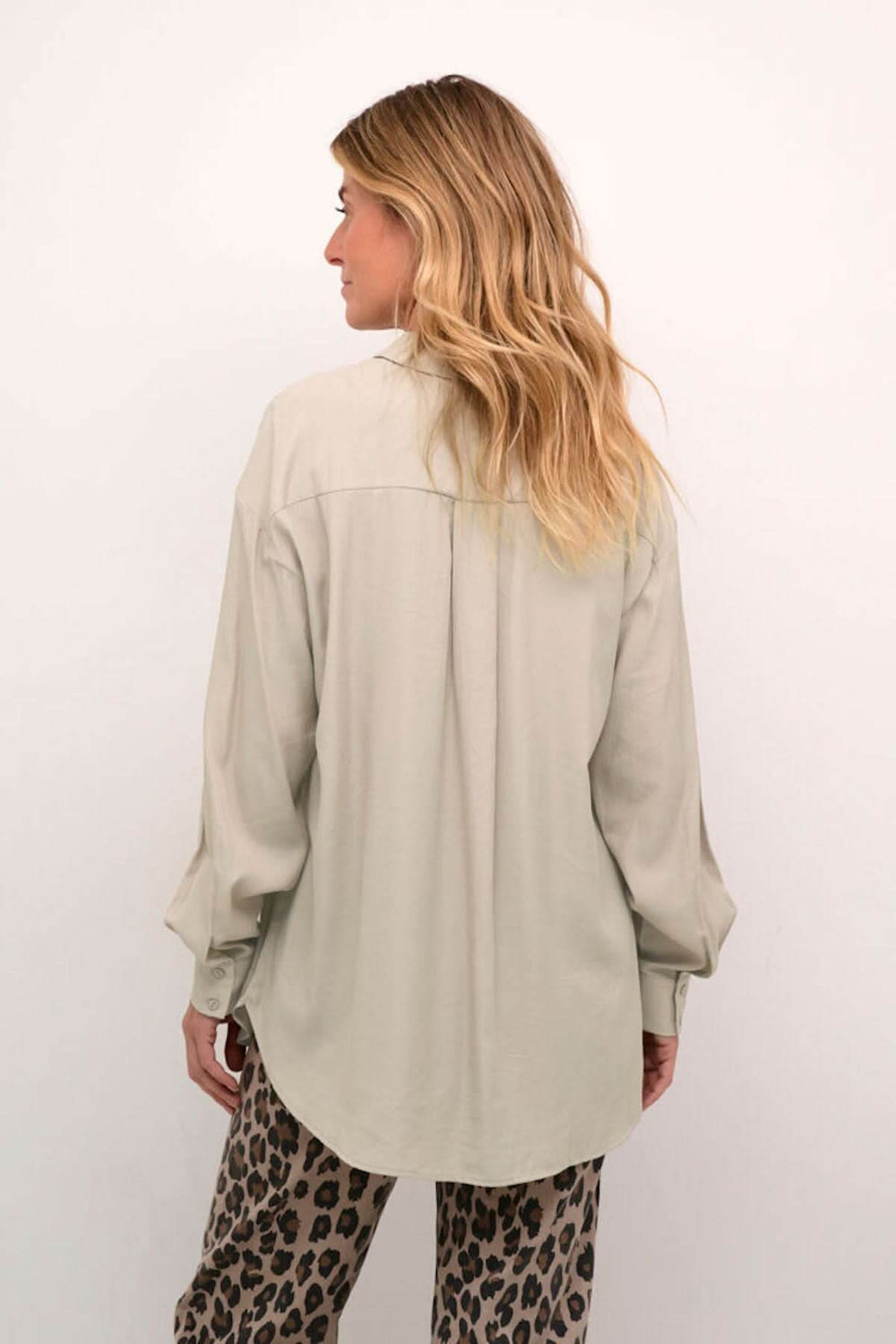 Chemise moderne à manches amples, vue de dos, avec poches sur la poitrine et coupe fluide.