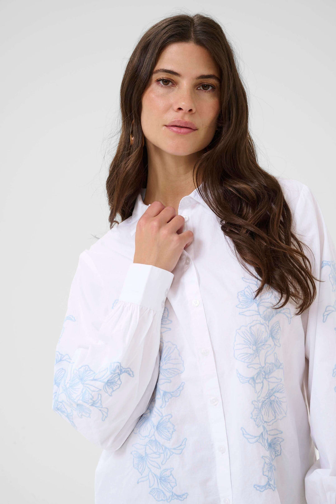 Femme portant la Chemise Jolene avec un motif floral délicat, coupe fluide et tissu léger, idéale pour un style professionnel ou décontracté.