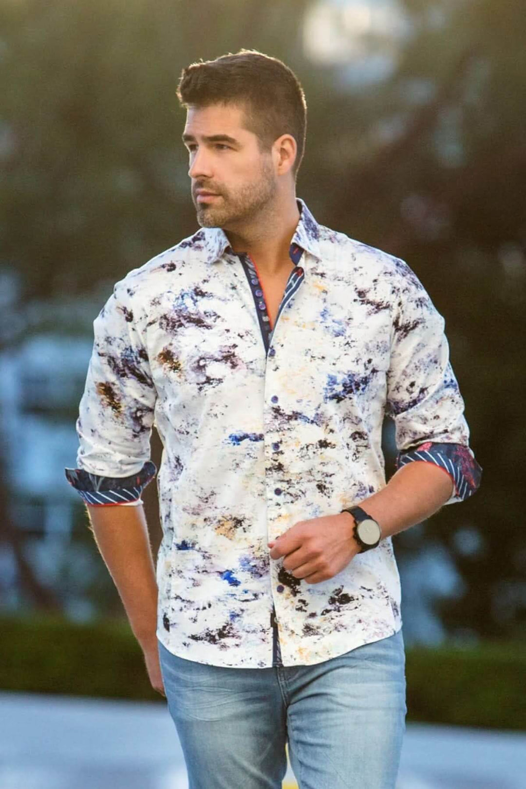 Homme portant une chemise Magnani à motif abstrait, avec détails contrastants, style élégant et décontracté.