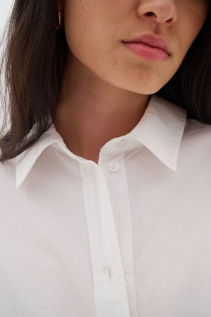 Col classique d'une chemise oversize blanche, mettant en valeur un style chic minimaliste et confortable.