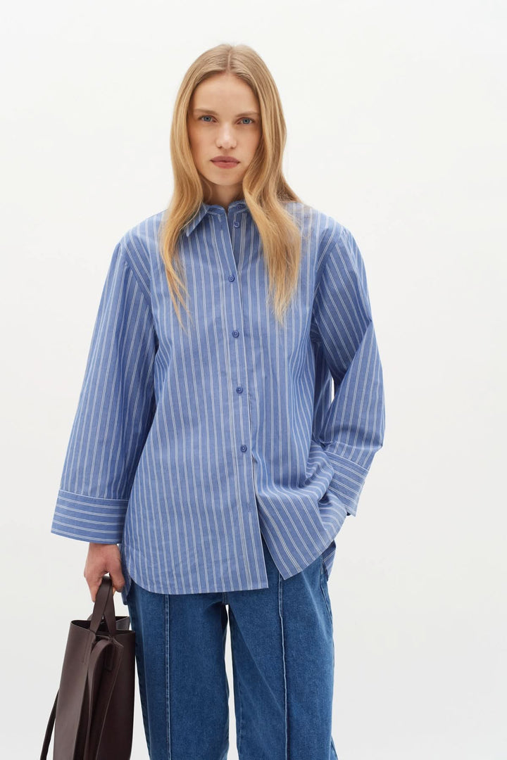 Chemise oversize bleue à rayures, col classique et manches longues, style décontracté et sophistiqué.