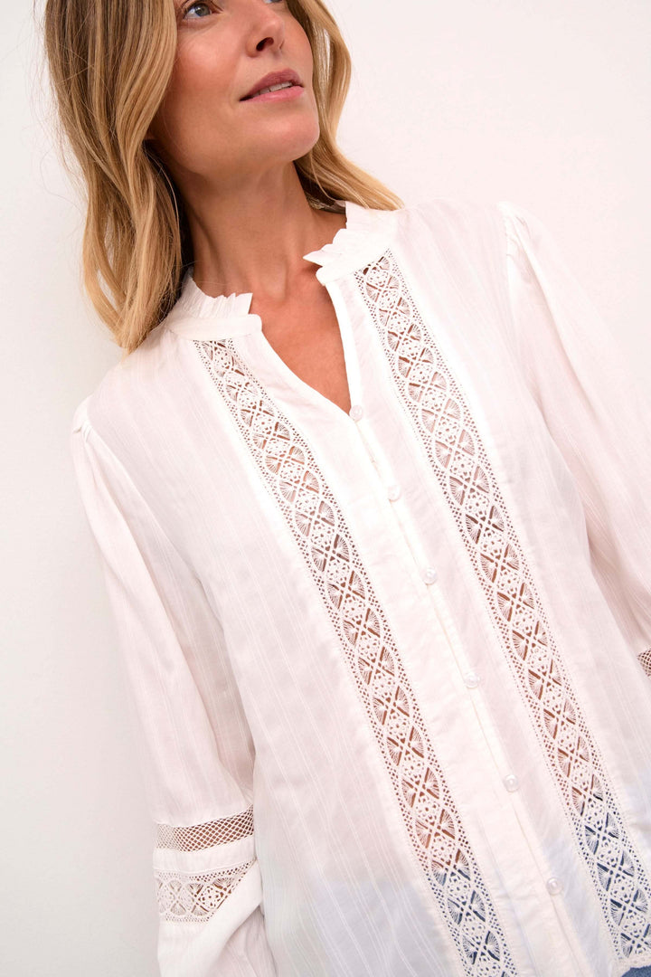 Chemise Paula romantique, avec empiècements en dentelle et manches longues, col rond fendu.