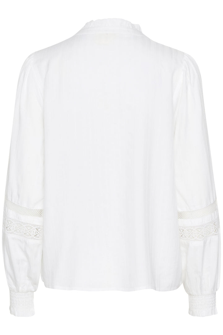 Chemise Paula, dos en blanc, avec manches bouffantes et empiècements en dentelle élégants, coupe fluide.
