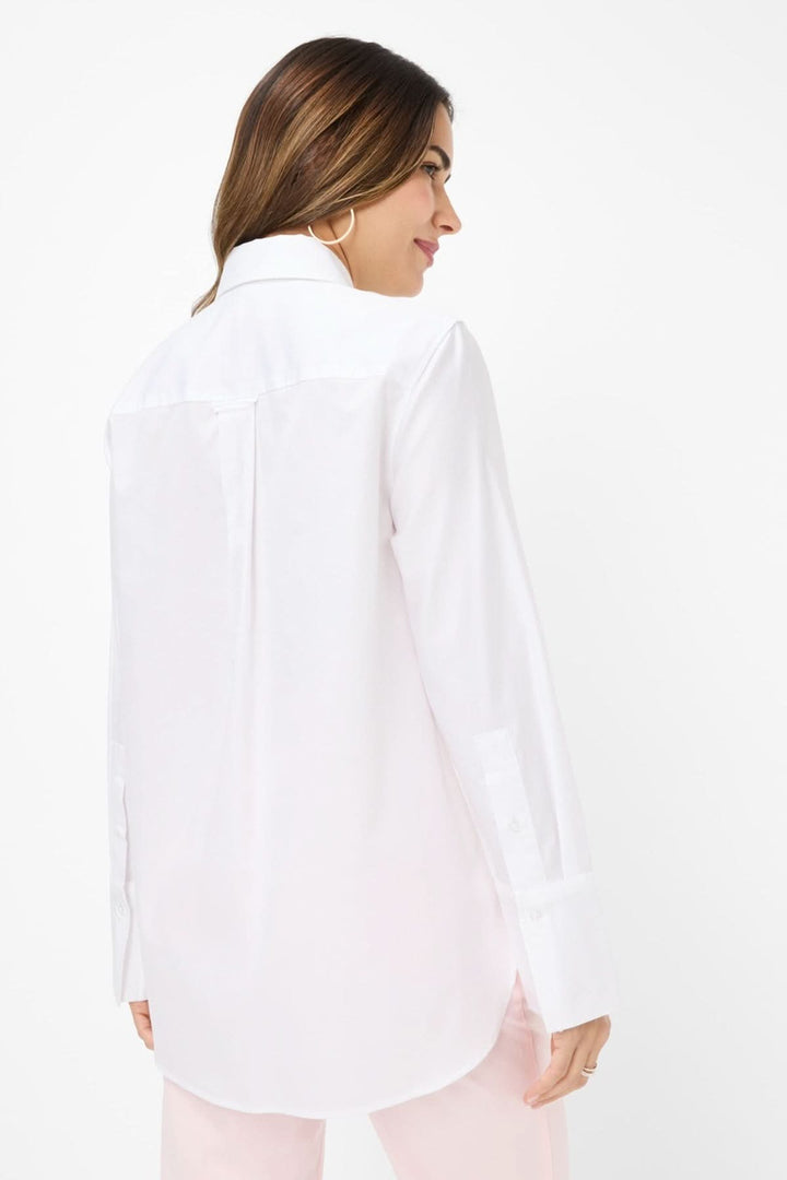 Femme portant le chemisier Viki, vue arrière, en blanc, style oversize avec col classique et poignets larges.