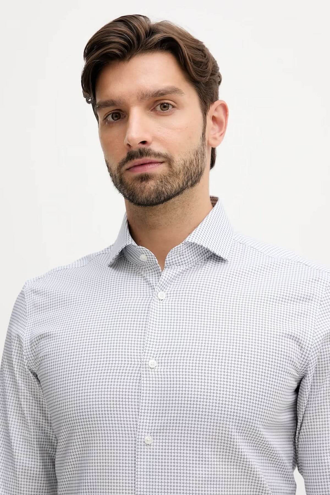 Homme portant une chemise ajustée à micro-motif élégante, idéale pour le bureau ou occasions habillées, manches longues, col classique.
