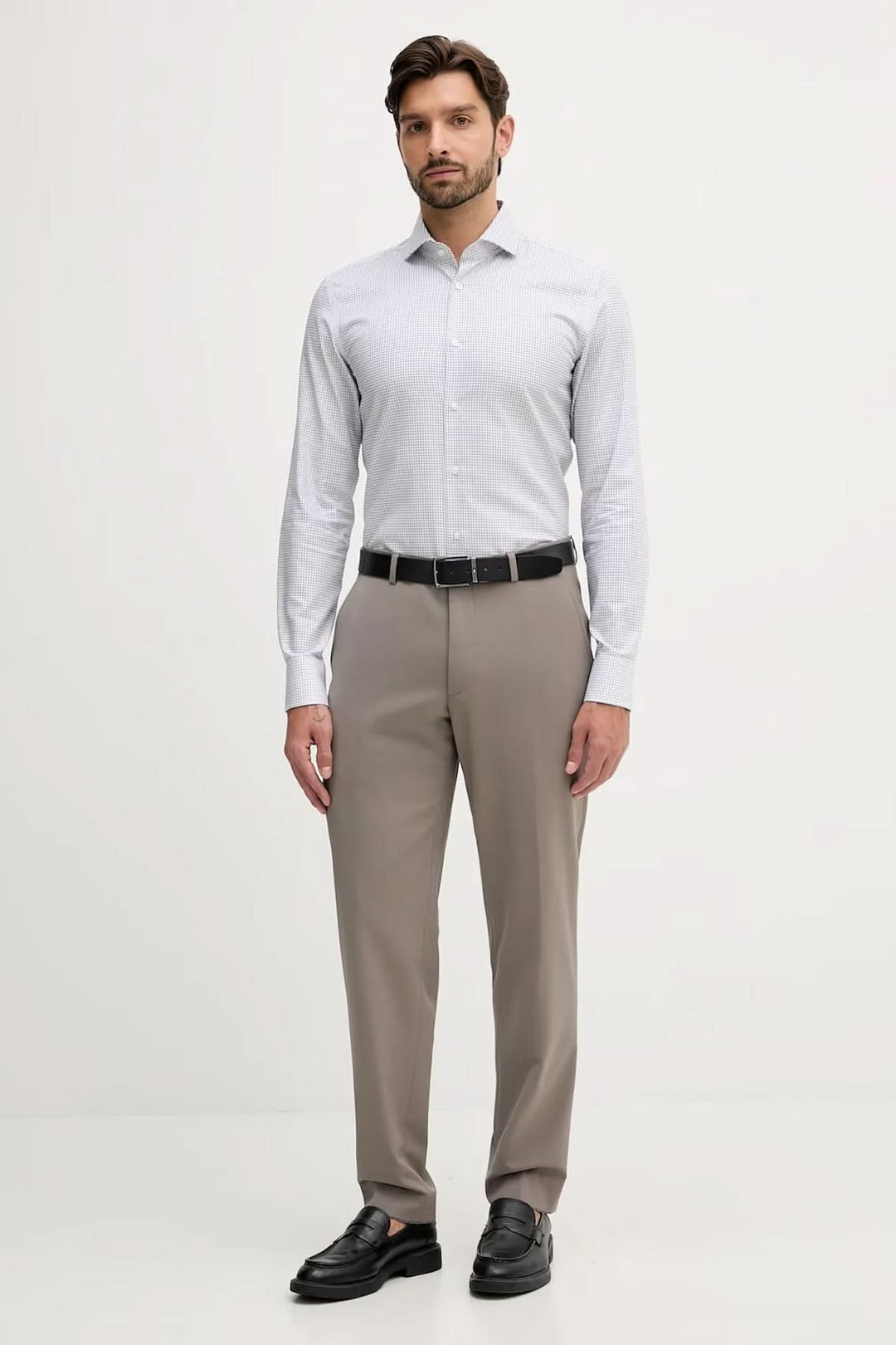Homme portant une chemise ajustée à micro-motif, élégante et moderne, idéale pour bureau et occasions habillées.