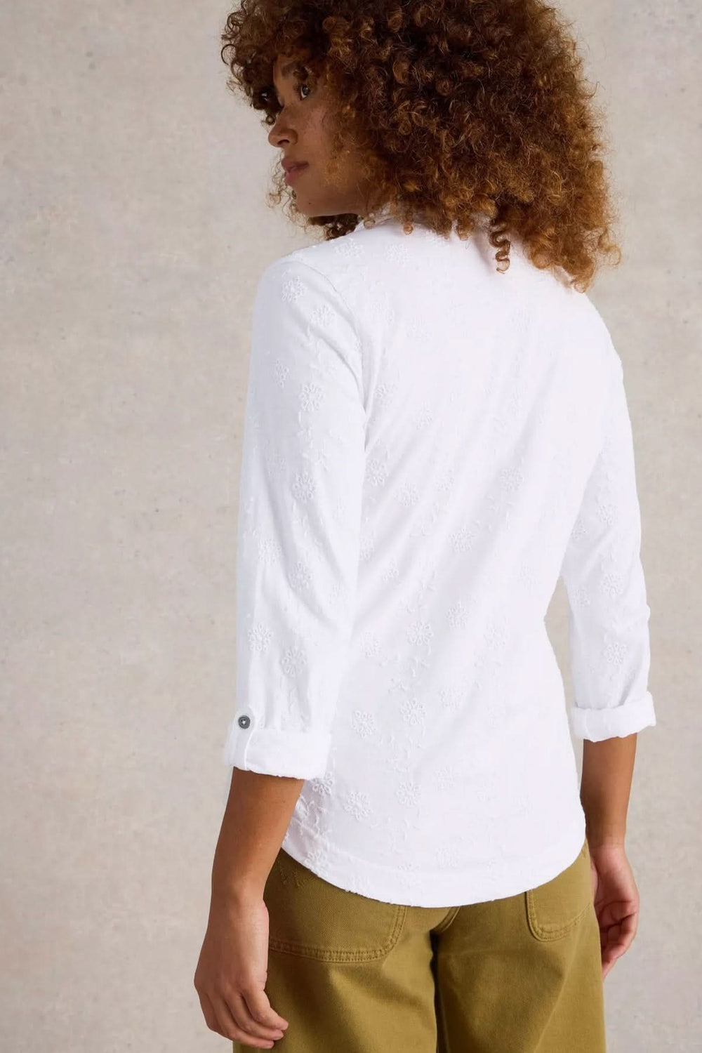Femme de dos portant une chemise blanche en coton avec manches 3/4 et détails élégants.