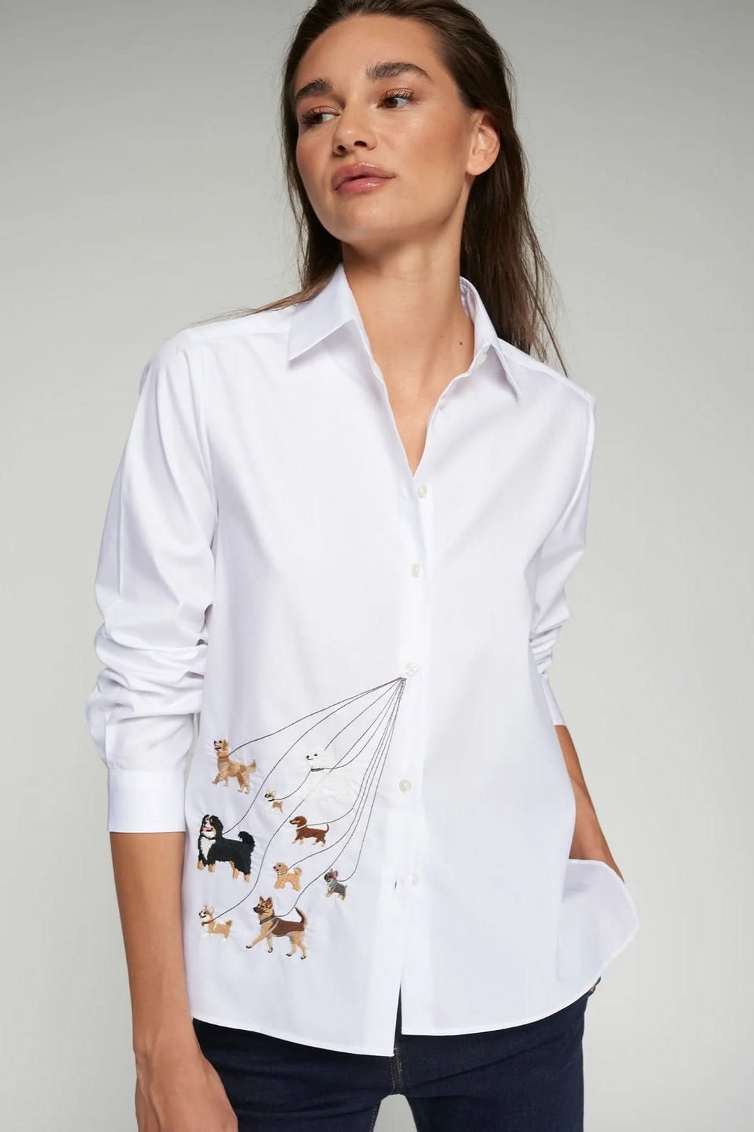 Femme portant une chemise brodée de chiens avec col structuré et manches longues.