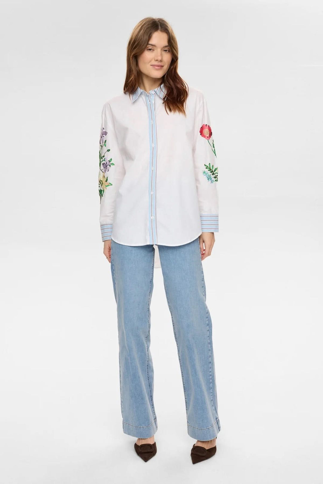 Chemise brodée à manches longues, élégante et artistique, avec broderies florales distinctives et manches longues.