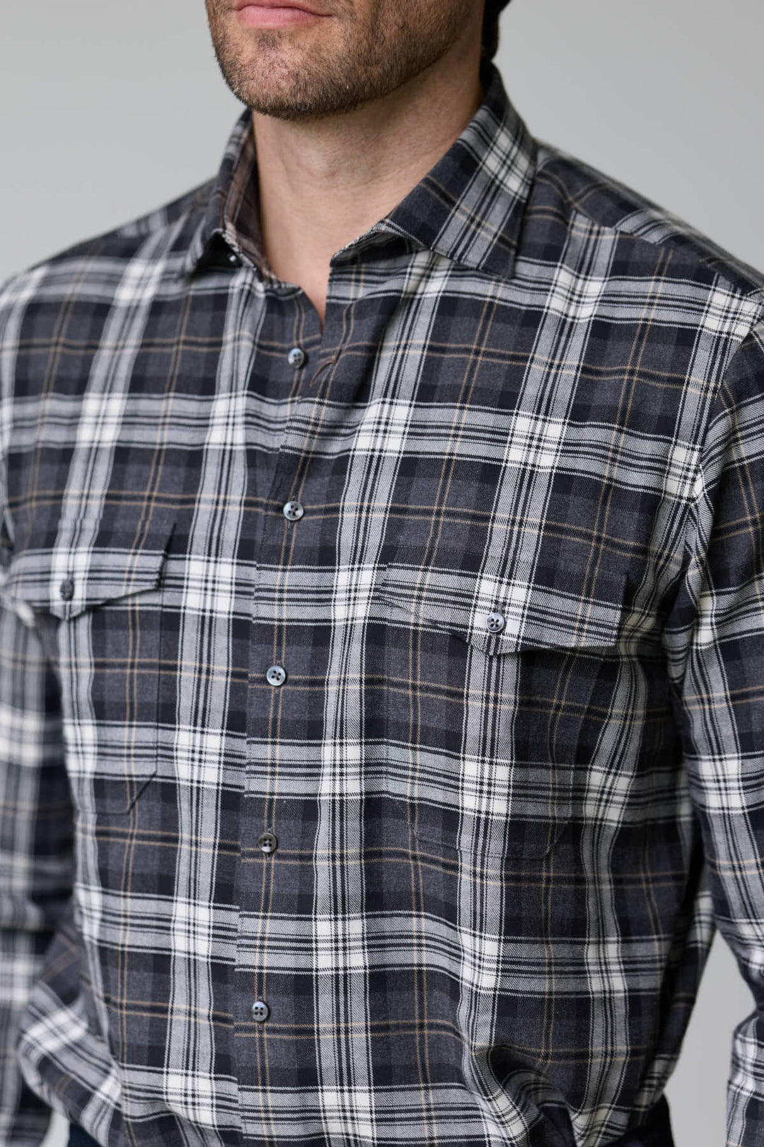 Homme portant une chemise à carreaux en flanelle douce, deux poches à rabat sur la poitrine et boutons ton sur ton pour un style décontracté.