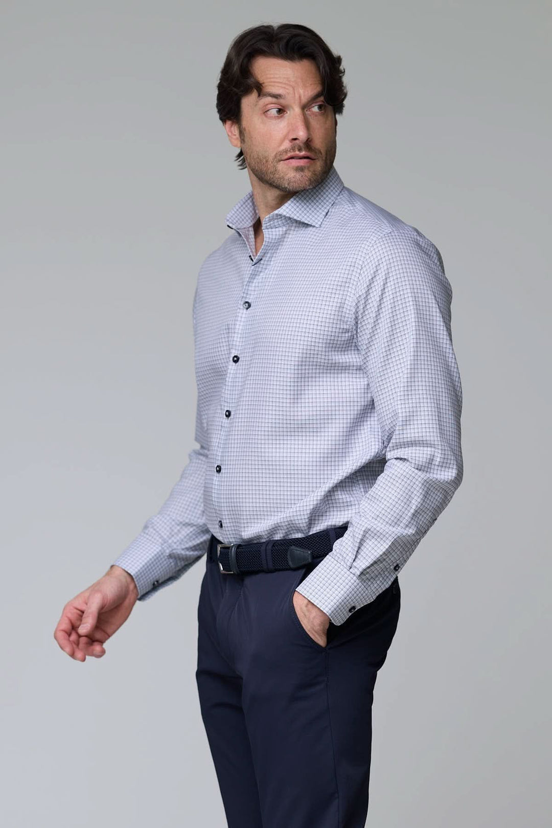 Homme portant une chemise à carreaux fins, manches longues, coupe ajustée, idéale pour un look professionnel et décontracté.