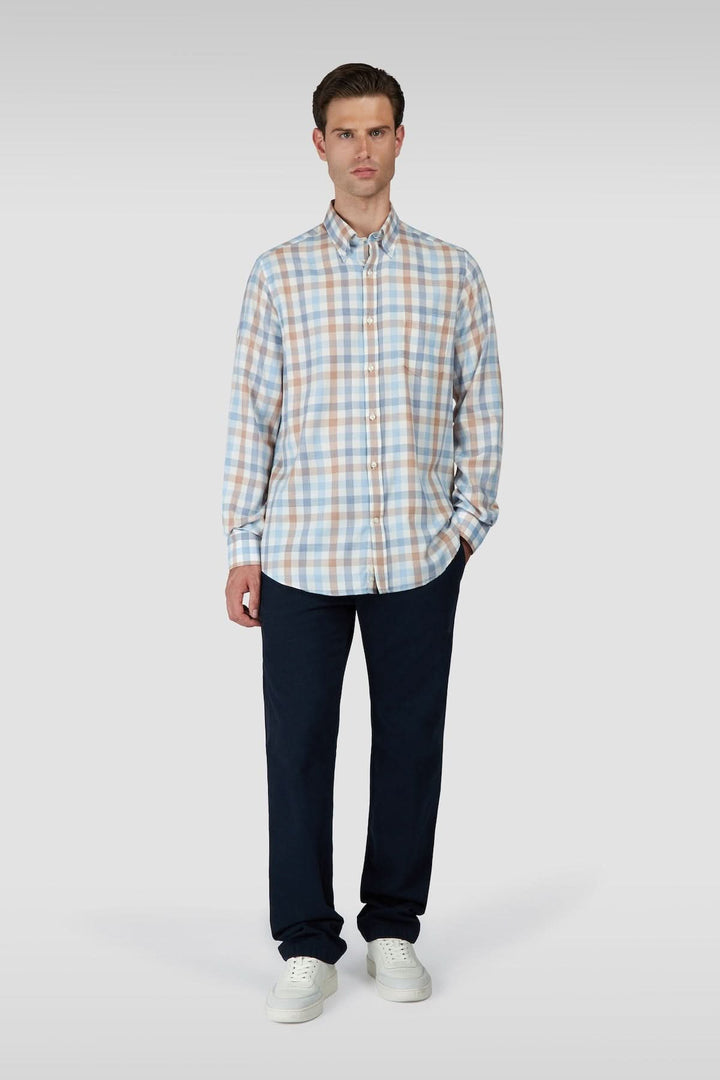 Homme portant une chemise à carreaux manches longues col boutonné, idéale pour un style classique et polyvalent.