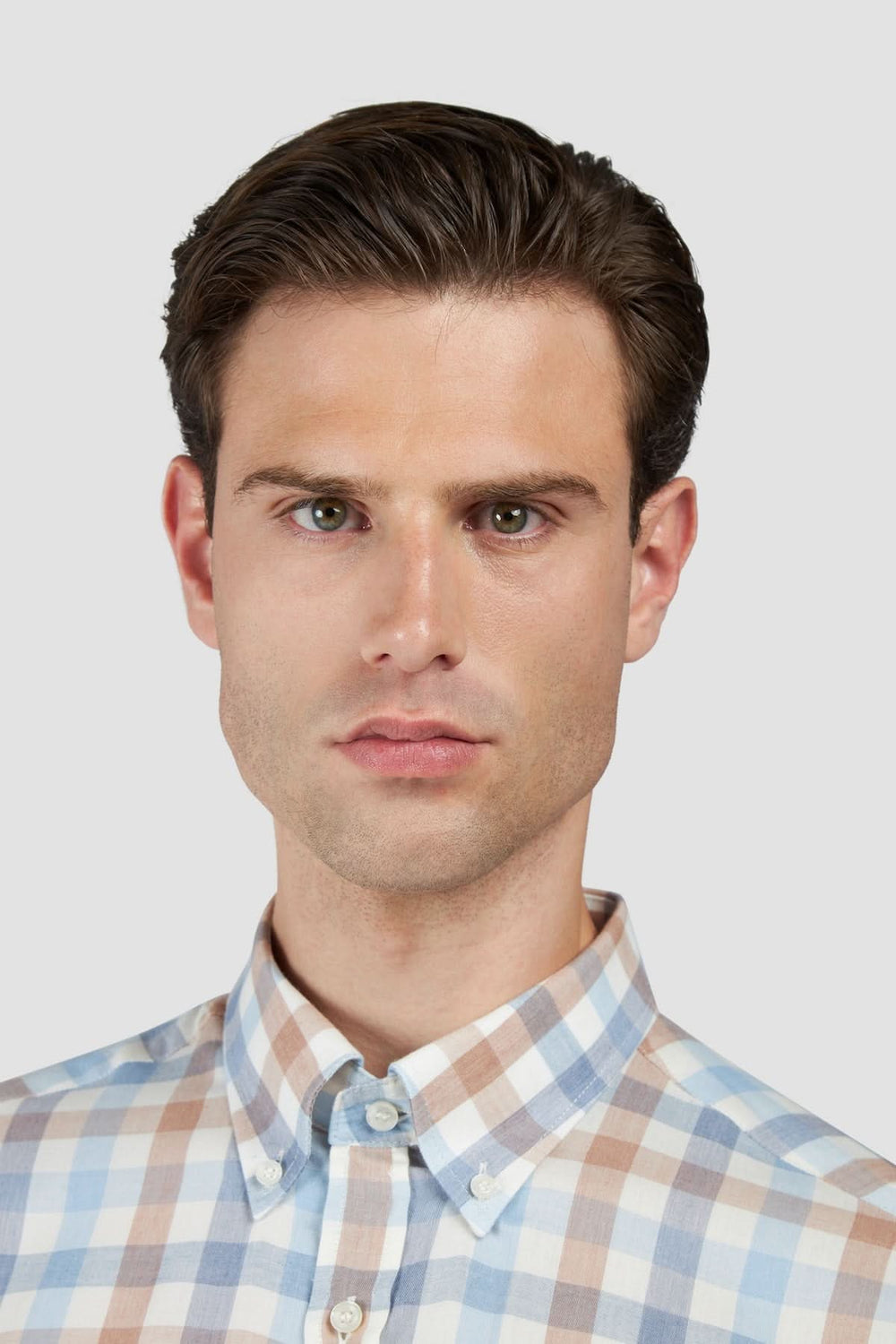 Homme portant une chemise à carreaux manches longues col boutonné, style classique, col button-down.