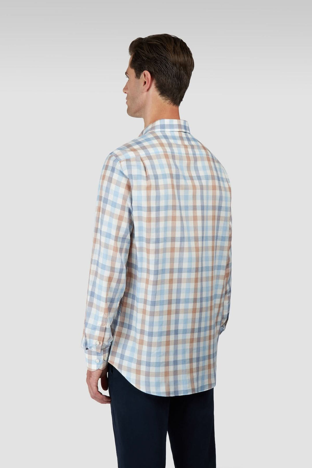 Homme portant une chemise à carreaux manches longues col boutonné, vue arrière, sur fond neutre.